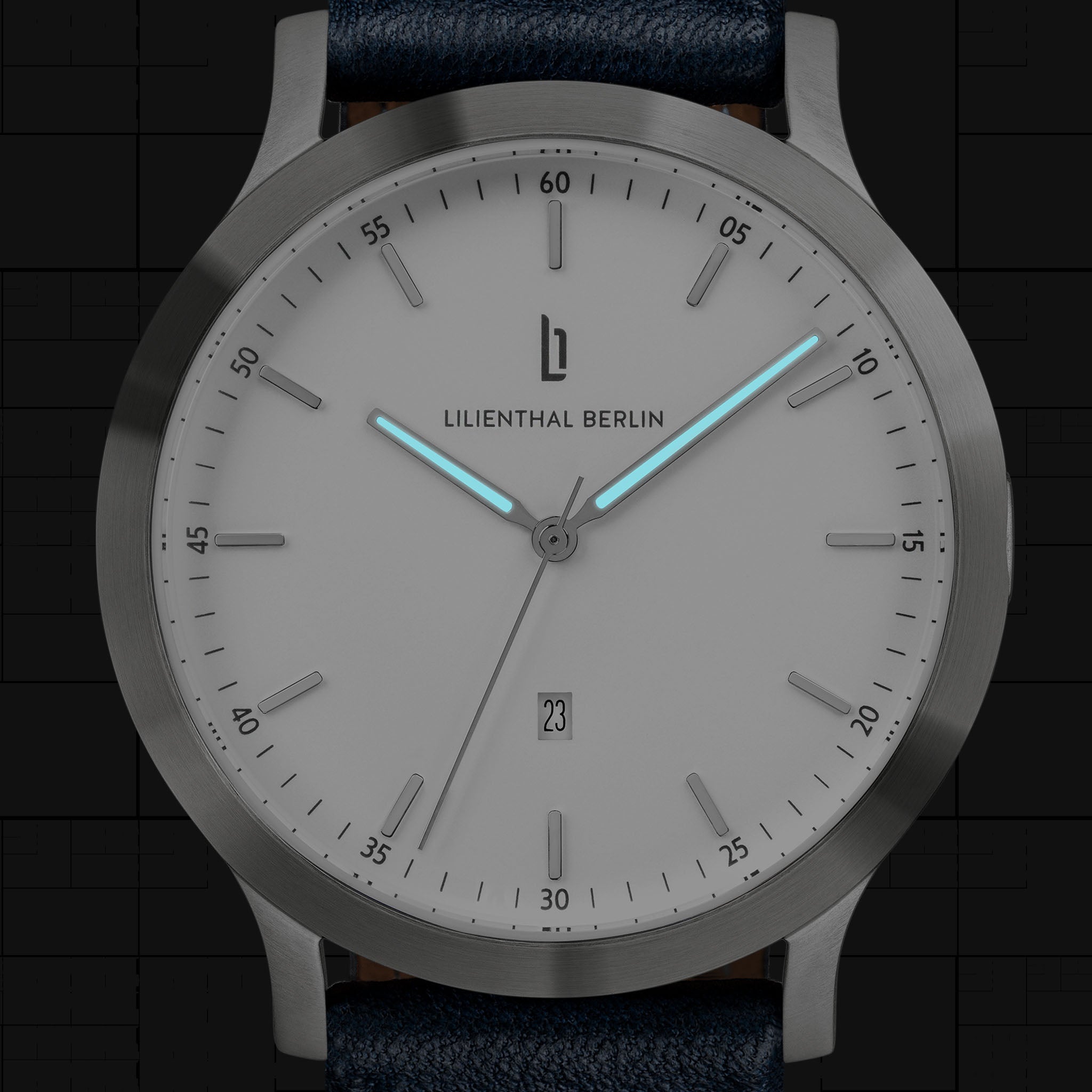 Minimalist silver watch with luminous blue hands, clean white dial, and date display