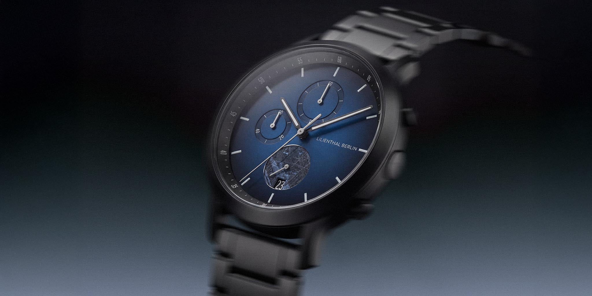 Chronograph watch with blue dial, three subdials, metal bracelet, and date display