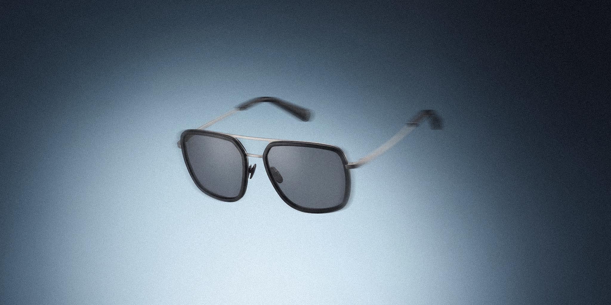 Modern aviator sunglasses with dark lenses and thin metal frame on gradient background