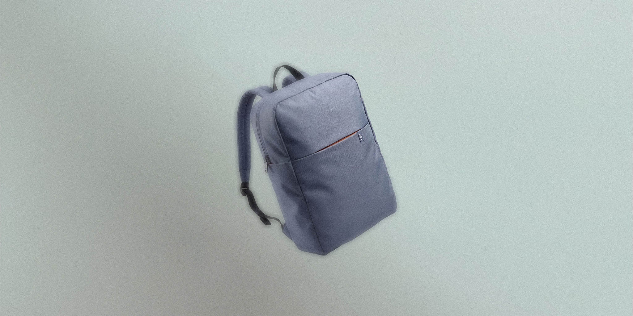 Minimalist grey backpack with front pocket and black straps on light background
