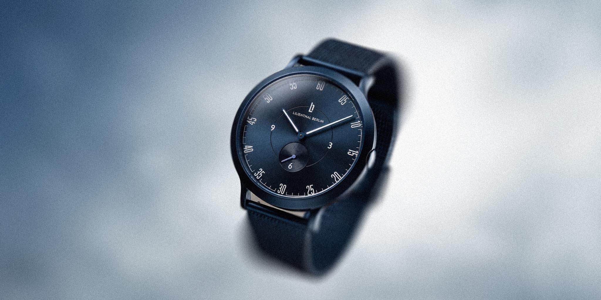 Minimalist blue chronograph watch with black strap and sleek dial design