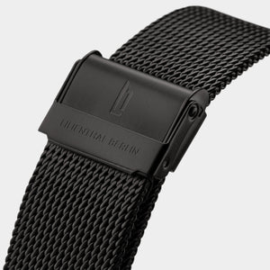 Black stainless steel mesh watch strap with engraved clasp, close-up view