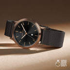 Minimalist black watch with rose gold case, mesh strap, and German Design Award 2021 badge