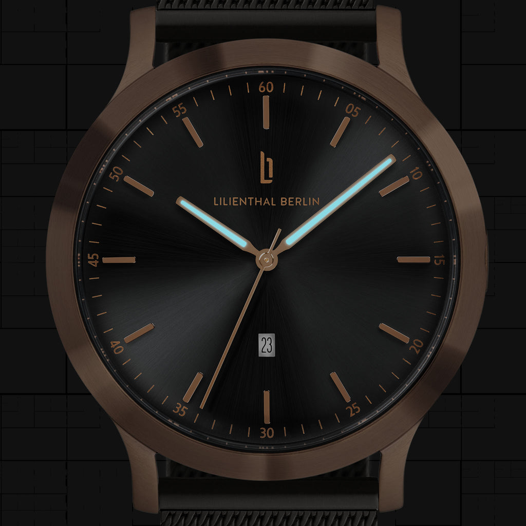Minimalist black watch with bronze case, date display, and luminous hands
