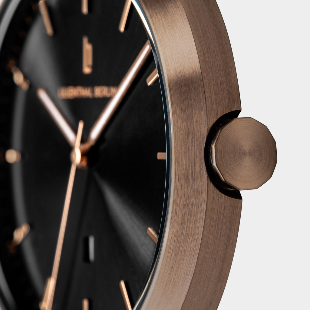 Close-up of a modern wristwatch with a black dial and rose gold case and details