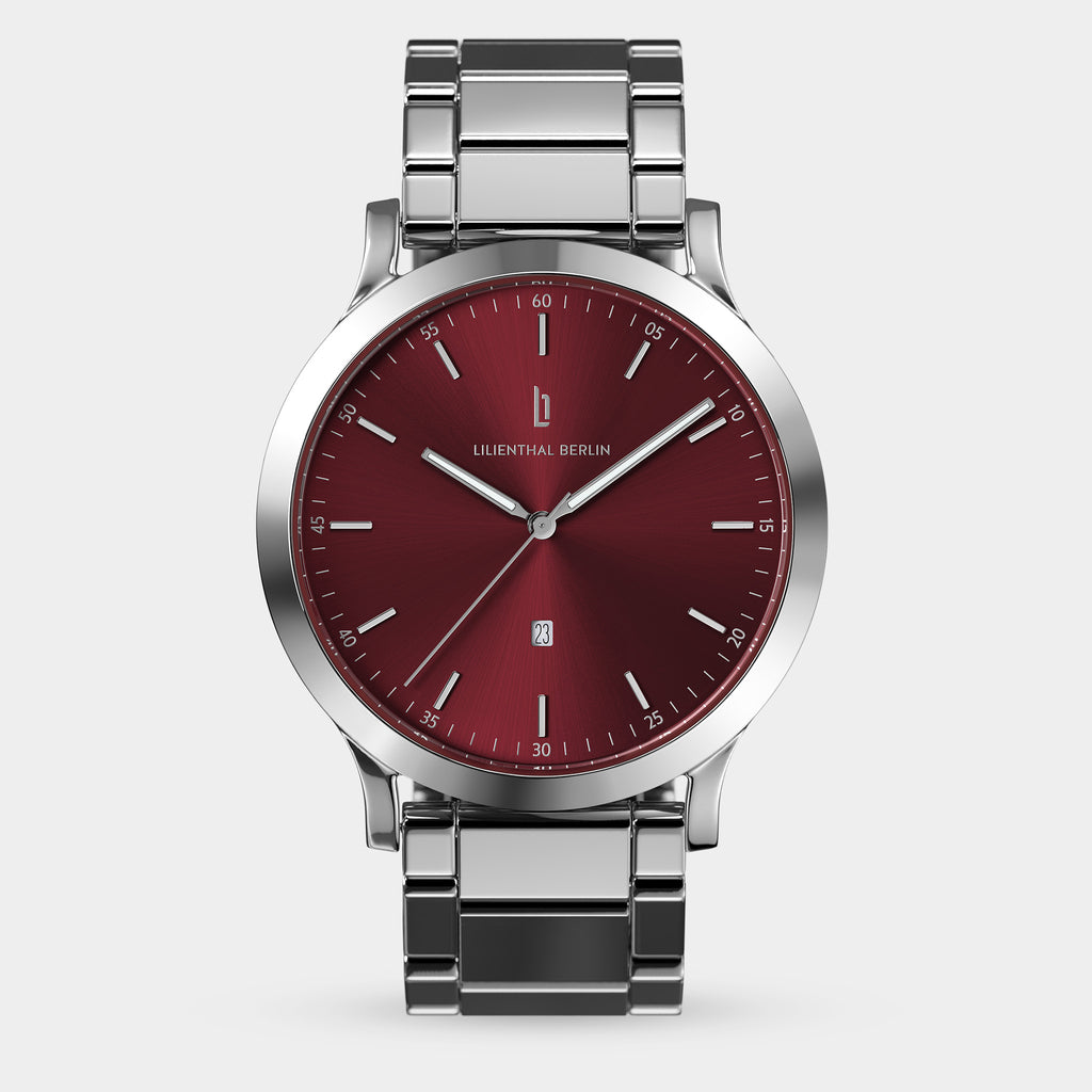 Silver metal watch with a red sunburst dial and date display, minimalist design