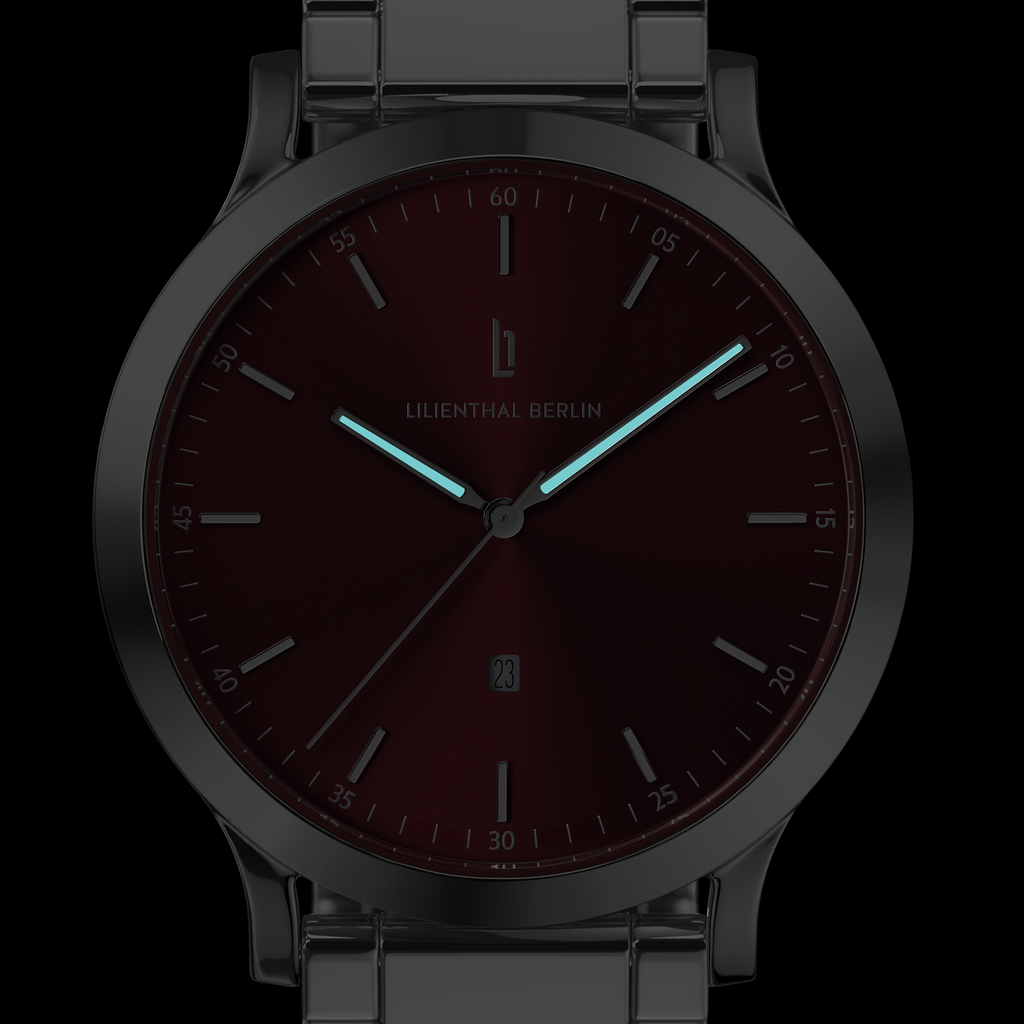 Minimalist men's watch with burgundy dial, luminous hands and metal link strap