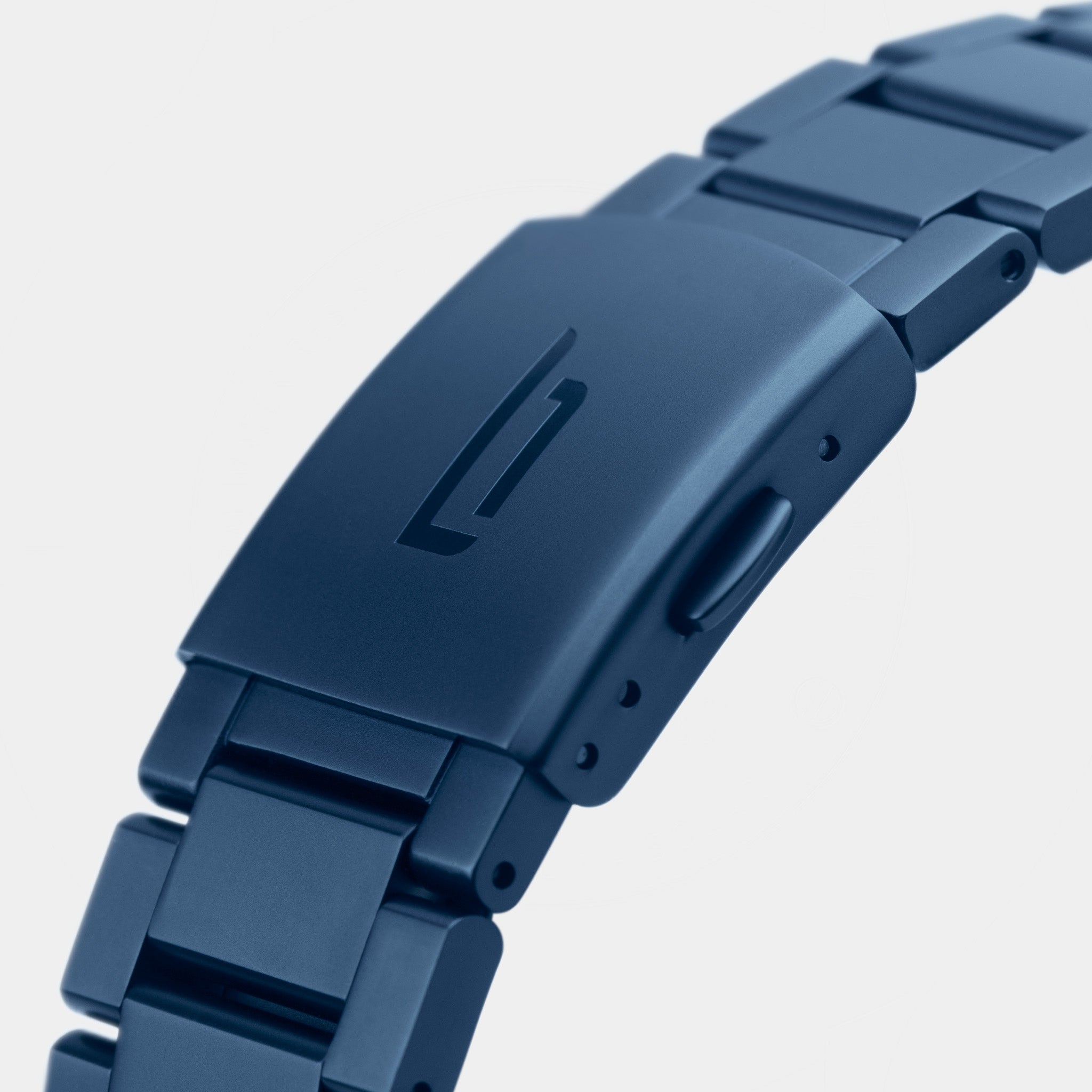 Close-up of a blue stainless steel watch bracelet clasp with engraved logo