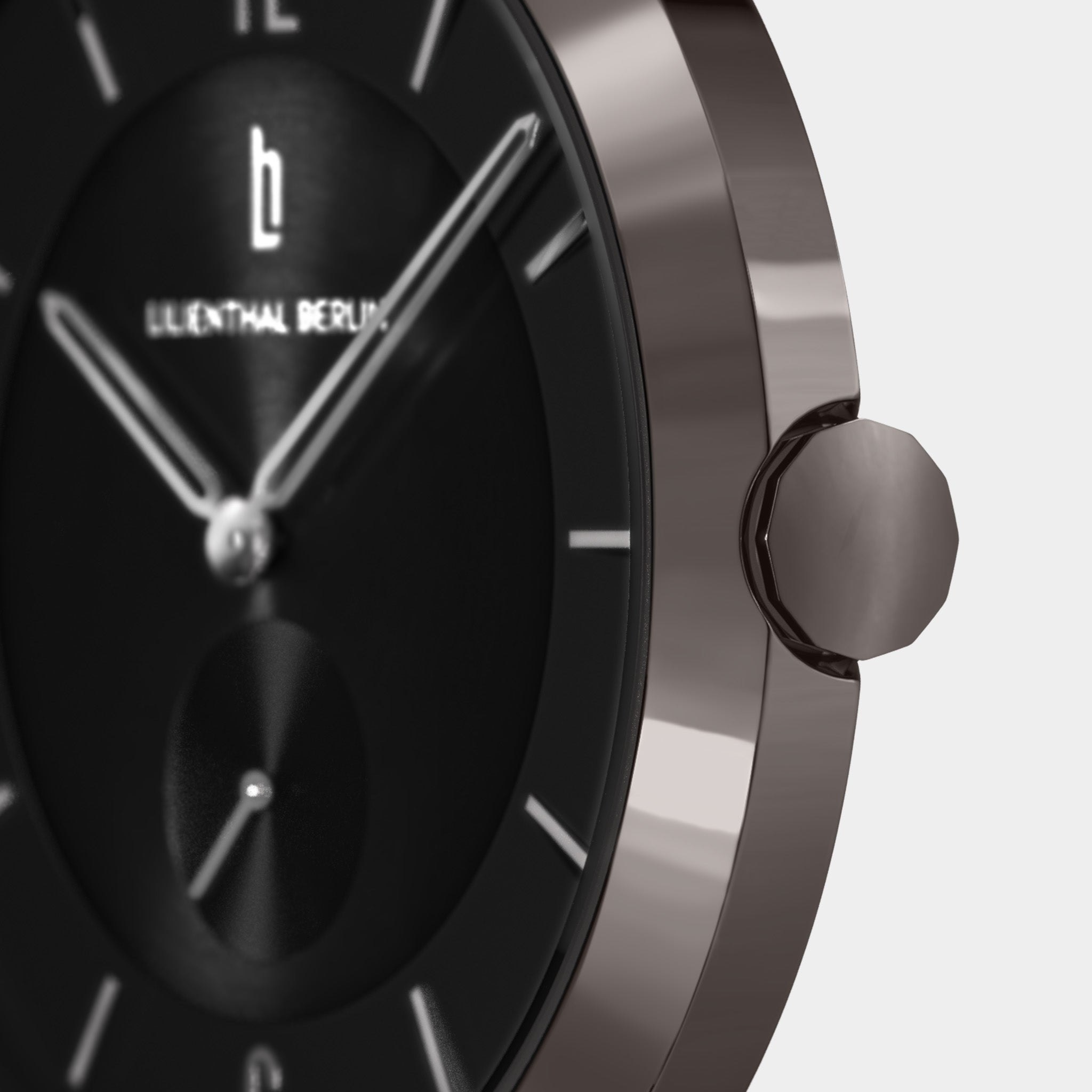 Close-up of a minimalist black watch face with silver hour markers and side crown