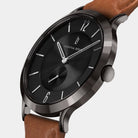 Modern black watch with brown leather strap, minimalist dial and silver accents