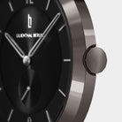 Close-up of a modern black watch face with silver hands and minimalist hour markers